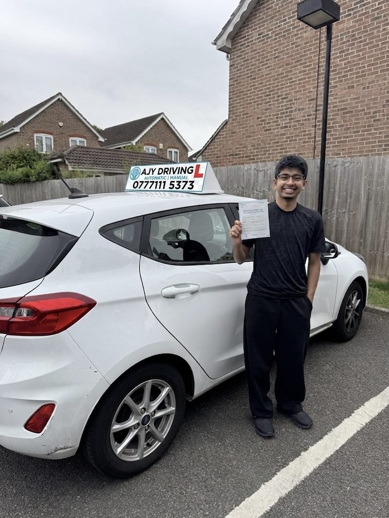 A learner standing proudly with their driving test pass certificate